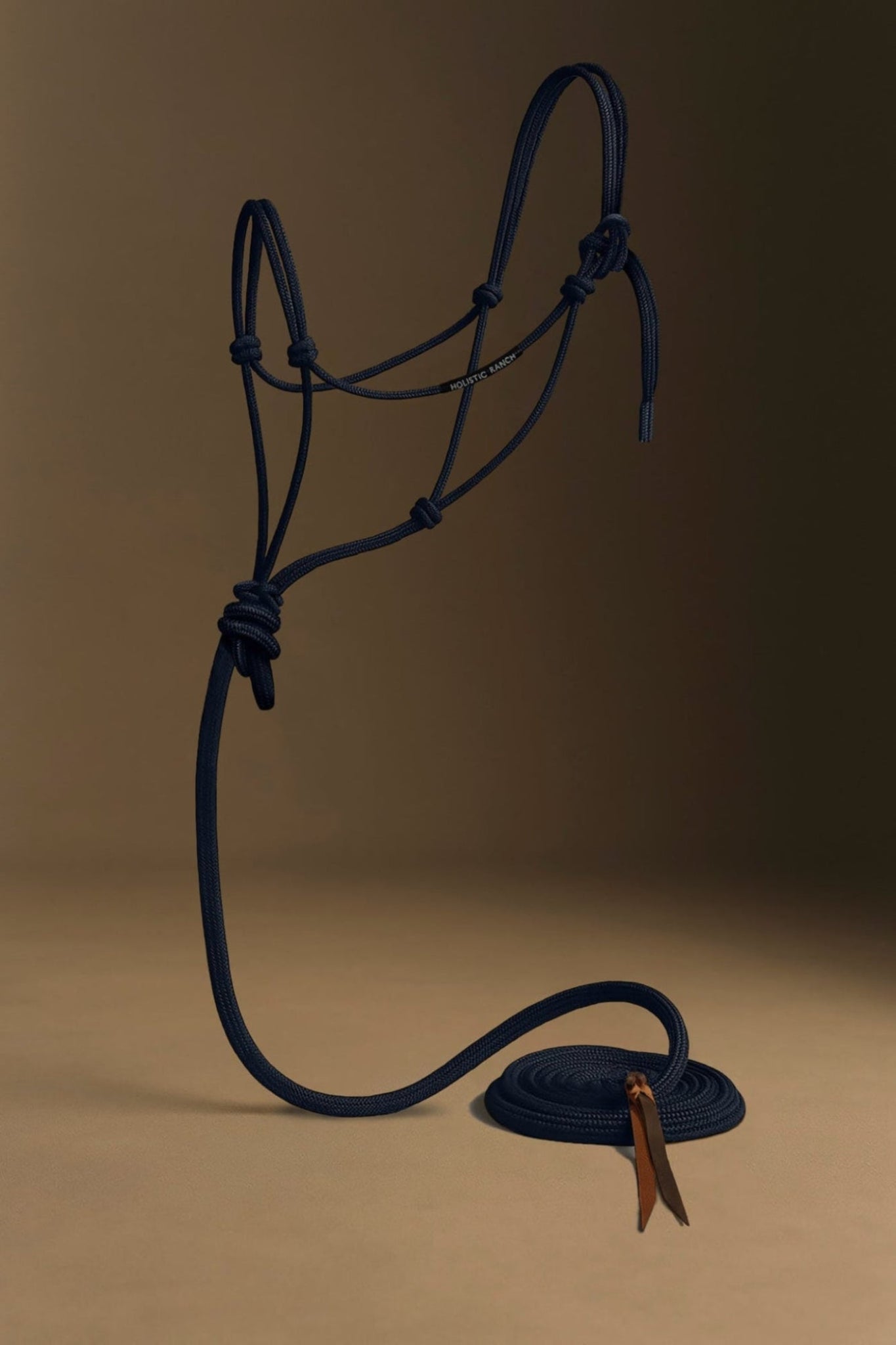 Navy blue horse rope halter with a brown leather buckle on a beige background